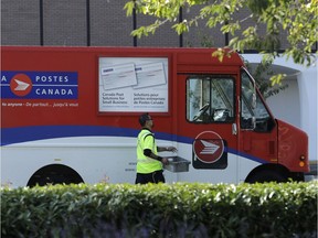 A Canada Post worker walks to his truck in Richmond, B.C., on Sept. 26.