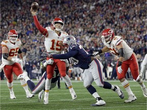 Kansas City Chiefs quarterback Patrick Mahomes (15) passes under pressure from New England Patriots defensive tackle Adam Butler during the first half of an NFL football game, Sunday, Oct. 14, 2018, in Foxborough, Mass.