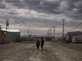 Three Arctic communities fear they've been cut off from crucial winter supplies after a government-owned company cancelled the annual supply barge that replenishes them. A family walks down the streets in Cambridge Bay, Nunavut, on Thursday, Aug. 31, 2017. Marine Transportation Services Ltd., owned by the Northwest Territories, says there's too much sea ice to run the scheduled barge to the central Arctic communities of Paulatuk, Kugluktuk and Cambridge Bay.