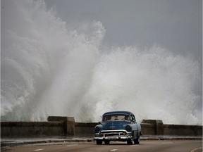 Waves crash against the Malecon, triggered by the outer bands of Hurricane Michael, as man drives past in a classic American car in Havana, Cuba, Tuesday, Oct. 9, 2018. A fast and furious Hurricane Michael is churning toward the Florida Panhandle with 110 mph winds and a potential storm surge of 12 feet, giving tens of thousands of people precious little time to get out.