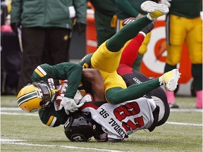 Eskimos wide receiver Bryant Mitchell is tackled by Redblacks defensive back Corey Tindal during Saturday's game in Edmonton.