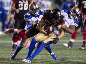 Ottawa Redblacks wide receiver Julian Feoli-Gudino is tackled by Winnipeg Blue Bombers defensive back Anthony Gaitor, left, and defensive back Kevin Fogg during second half CFL action in Ottawa on Friday, Oct. 5, 2018. The Blue Bombers defeated the RedBlacks 40-32 in overtime.