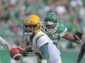 Eskimos quarterback Mike Reilly is brought down by Roughriders defensive lineman Willie Jefferson during the first half of play in Regina on Monday.