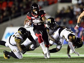 Redblacks running back William Powell runs through a series of Ticats defenders in the second half of Friday's game at TD Place stadium.