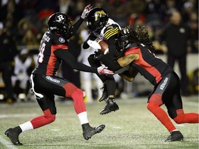 Hamilton Tiger-Cats wide receiver Brandon Banks (16) gets tackled by Ottawa Redblacks defensive back Devin Butler (14), left, and Ottawa Redblacks defensive back Rico Murray (3) in Ottawa on Friday, Oct. 19, 2018.