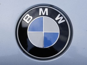 FILE - In this Aug. 1, 2017 file photo the brand logo of German car maker BMW is photographed on a car in Berlin. BMW said it is expanding a recall to cover 1.6 million vehicles worldwide due to possible fluid leaks that could result in a fire.