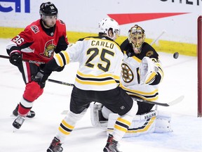Bruins goaltender Tuukka Rask and defenceman Brandon Carlo keep their on the puck along with Senators centre Colin White during the second period of Tuesday's game.