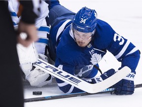 Toronto Maple Leafs centre Auston Matthews battles for the loose puck with Winnipeg Jets goaltender Connor Hellebuyck during the first period in Toronto on Saturday, Oct. 27, 2018.