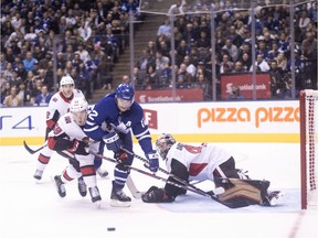Senators rookie Maxime Lajoie (58) helps out netminder Craig Anderson defensively in an Oct. 6 contest against the Maple Leafs in Toronto.