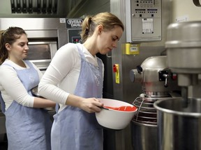 Baker Sophie Cabot, right, prepares the red velvet and chocolate wedding cake for Britain's Princess Eugenie and Mr Brooksbank, in the kitchens at Buckingham Palace, London, Wednesday Oct. 10, 2018. The granddaughter of Queen Elizabeth II is due to marry liquor company executive Jack Brooksbank on Friday in St. George's Chapel at Windsor Castle.