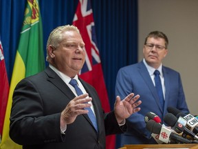 Ontario Premier Doug Ford speaks as Saskatchewan Premier Scott Moe listens during a media event in Saskatoon, October 4, 2018.