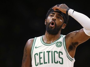 Boston Celtics guard Kyrie Irving reacts during the first quarter of a preseason basketball game against the Charlotte Hornets in Boston, Sunday, Sept. 30, 2018.