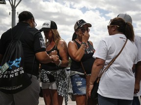 Norma Felix, center right, and Cheryl Seguin, center left, pray with others at a prayer service on the anniversary of the Oct.1, 2017 mass shooting, Monday, Oct. 1, 2018, in Las Vegas. The two attended the country music festival last year and came back to Las Vegas for the anniversary.