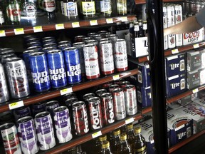 FILE - This Wednesday, April 19, 2017 file photo shows the beer cooler behind the counter in a convenience store in Sheridan, Ind. In future sweltering years with a double whammy of heat and drought, losses of barley yield can be as much as 17 percent, computer simulations show. And that means "beer prices would, on average, double," even adjusting for inflation, said a study published in the journal Nature Plants on Wednesday, Oct. 17, 2018.