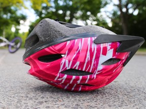 A bike helmet lies on the road in front of a crashed bike in this photo illustration. Safe Kids Week is happening from May 30th ñ June 5th in communities across Canada, with a focus on the top injury issues that affect children At Home, At Play and On The Road. Tim Miller/Belleville Intelligencer/Postmedia Network
