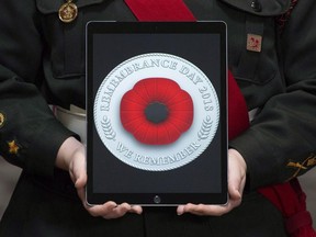 A cadet holds a tablet showing the digital poppy during a ceremony marking the start of the Canadian Legion's Remembrance Day poppies at the Beechwood National Memorial centre Monday, October 22, 2018 in Ottawa. The Remembrance Day poppy has entered the digital age. The Royal Canadian Legion launched a digital version of the distinctive red flower, which it says can be customized, shared online and used as a profile image on sites including Facebook, Twitter, Instagram and LinkedIn.