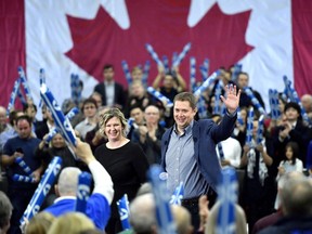 Conservative leader Andrew Scheer waves to supporters as his wife Jill joins him on stage, following a pre-election event in Ottawa on Sunday, Oct. 21, 2018.
