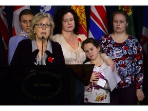 Elizabeth May, Leader of the Green Party, calls on the Government of Canada to urgently intervene in the case of Dr. Elena Musikhina, middle back, in Ottawa on Tuesday, Oct. 30, 2018. Musikhina, who holds her granddaughter Iaroslava Sunatori, 8, and her husband have been summoned by the CBSA for issuance of a deportation order.
