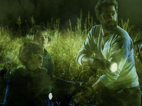 Noah Jupe, from left, Millicent Simmonds and John Krasinski in a scene from A Quiet Place.