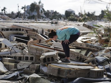 Mishelle McPherson looks for her friend in the rubble of her home, since she knows she stayed behind in the home during Hurricane Michael, in Mexico Beach, Fla., Thursday, Oct. 11, 2018.