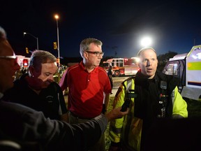 Ottawa Mayor Jim Watson, centre, takes part in a briefing as paramedic gives an update following a tornado in Dunrobin, Ontario west of Ottawa on Friday, Sept. 21, 2018. Watson tweeted put lots of information for citizens trying to stay up to-date on rescue and relief efforts. But some people are blocked from his social media account.