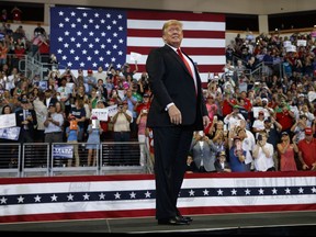 FILE - In this Oct. 10, 2018, file photo, President Donald Trump arrives to speak at a campaign rally at Erie Insurance Arena, in Erie, Pa. President Donald Trump's campaign rallies once had the feel of angry, raucous grievance sessions. More than 350 rallies later, gone is the darkness, the crackling energy, the fear of potential violence as supporters and protesters face off. Perish the thought, have Donald Trump's rallies gone mainstream?