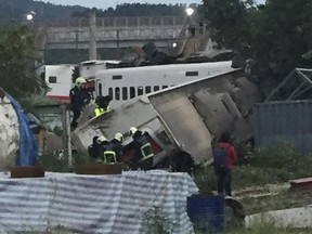 In this photo released by Li Jun, rescue workers are seen at the site of a train derailment in Lian in northern Taiwan on Sunday, Oct. 21, 2018.