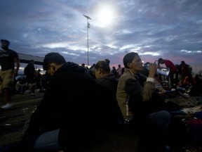 Migrants bound for the U.S.-Mexico border wait on a bridge that stretches over the Suchiate River, connecting Guatemala and Mexico, in Tecun Uman, Guatemala, early Saturday, Oct. 20, 2018. The entry into Mexico via the bridge has been closed. The migrants have moved about 30 feet back from the gate that separates them from Mexican police to establish a buffer zone. About 1,000 migrants now remain on the bridge between Guatemala and Mexico.