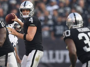 Derek Carr #4 of the Oakland Raiders looks to pass against the Los Angeles Chargers during their NFL game at Oakland-Alameda County Coliseum on November 11, 2018 in Oakland, California.