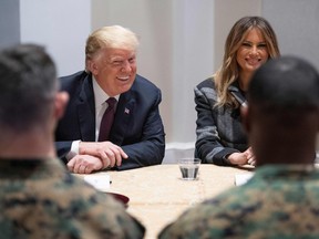 U.S. President Donald Trump (C) and First Lady Melania Trump talk with U.S. Marines as they visits the Marine Barracks in Washington DC, on November 15, 2018.
