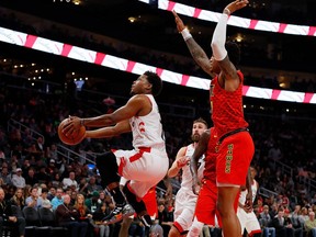 Kyle Lowry #7 of the Toronto Raptors drives against John Collins #20 of the Atlanta Hawks at State Farm Arena on November 21, 2018 in Atlanta, Georgia.  NOTE TO USER: User expressly acknowledges and agrees that, by downloading and or using this photograph, User is consenting to the terms and conditions of the Getty Images License Agreement.