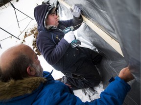 Len Russell of the West Carleton Disaster Relief and Murray Martin of Riverside Construction were helping fix a tarp on a home on Cricket Crescent in Dunrobin on Friday.