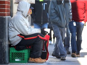 A homeless man begs for money with a plastic cup on Elgin near City Hall earlier this year.