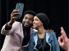 Ilhan Omar, right, newly elected to the U.S. House of Representatives on the Democratic ticket, poses with a supporter in Minneapolis on Tuesday night.