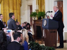 US President Donald Trump (R) gets into a heated exchange with CNN chief White House correspondent Jim Acosta (C) as NBC correspondent Peter Alexander (L) looks on during a post-election press conference in the East Room of the White House in Washington, DC on November 7, 2018.