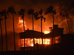 A house burns in Malibu, California. About 75,000 homes have been evacuated in Los Angeles and Ventura counties due to two fires in the region.