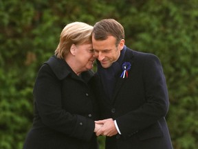 French President Emmanuel Macron and German Chancellor Angela Merkel hold hands after unveiling a plaque in a French-German ceremony in the clearing of Rethondes (the Glade of the Armistice) in Compiegne, northern France, on November 10, 2018.