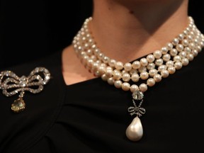 (FILES) In this file photo taken on October 19, 2018 a model wears The 'Queen Marie Antoinette's Pearl' with an estimated value of £767,500-£1,534,000 GBP (872,500-1,743,000 Euros, $1,000,000-2,000,000 USD) on Queen Marie Antoinette's pearl and diamond necklace, together with a Queen Marie Antoinette's diamond brooch (L) during a photocall for the sale of 'Royal Jewels from the Bourbon Parma Family' at Sotheby's auction house in London on October 19, 2018. - One of the most important royal jewellery collections ever to come to auction comes for sale at Sothebys in Geneva on November 14, 2018. Entitled Royal Jewels from the Bourbon-Parma Family, the auction will span centuries of European history, from the reign of Louis XVI to the fall of the Austro-Hungarian Empire.