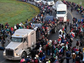 Migrants from poor Central American countries -mostly Hondurans- moving towards the United States in hopes of a better life, wait along the Irapuato-Guadalajara highway in the Mexican state of Guanajuato for a ride to Guadalajara on their trek north, on November 12, 2018. - The United States embarked Friday on a policy of automatically rejecting asylum claims of people who cross the Mexican border illegally in a bid to deter Central American migrants and force Mexico to handle them.