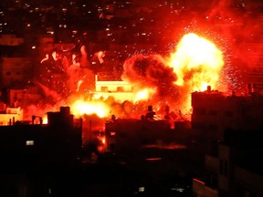 A picture taken on November 12, 2018, shows a ball of fire above the building housing the Hamas-run television station al-Aqsa TV in the Gaza Strip during an Israeli air strike.