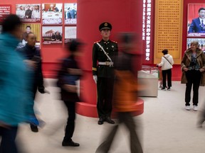 People walk past a Chinese paramilitary policeman at an exhibition marking the 40th anniversary of China's reform and opening up, at the National Museum of China in Beijing on November 16, 2018. (Photo by FRED DUFOUR / AFP)FRED DUFOUR/AFP/Getty Images