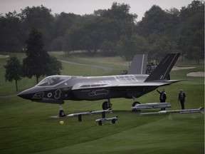 Six years after blowing up the Harper government's plans to buy the F-35 stealth fighter without a competition, Auditor General Michael Ferguson is preparing to release a new report on Canada's tumultuous attempts to buy new fighter jets. Men look at a demonstration F35 jet standing on display beside a golf course prior to a NATO summit at the Celtic Manor Resort in Newport, Wales, Wednesday, Sept. 3, 2014.