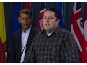 Canadian Labour Congress President Hassan Yussuff looks on as Canadian Union of Postal Workers President Mike Palecek speaks during a news conference on Parliament Hill Friday November 23, 2018 in Ottawa.