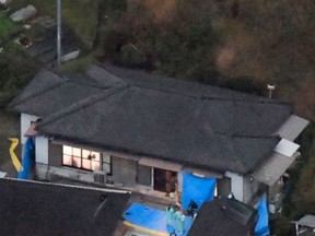 Blue plastic sheets cover the site where six bodies believed to be members of a family were found at a farmhouse in Takachiho, Miyazaki prefecture, southwestern Japan, Monday, Nov. 26, 2018.