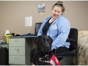 Carrie Lemay, 43, sits with her new diabetic alert dog, Freckles, at the Dog Guides Canada facility in Oakville, Ont. on Wednesday, November 14, 2018. The dogs are trained to detect low blood sugar levels in people with Type 1 diabetes and to alert them by pawing at them.