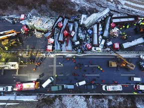In this Monday, Nov. 21, 2016 photo released by Xinhua News Agency, rescuers work near vehicles collided on the Pingyang section of Beijing-Kunming expressway in north China's Shanxi Province. A vehicle pile-up in snowy weather in northern China that involved more than 50 vehicles has led to the deaths of more than a dozen of people, state media reported.
