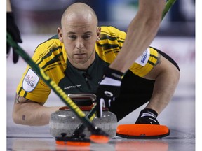 Northern Ontario third Ryan Fry makes a shot as his team plays Newfoundland and Labrador during curling action at the Brier in Calgary, Thursday, March 5, 2015. A curling team skipped by Jamie Koe of the Northwest Territories which included Olympic gold medal winner Ryan Fry has been ejected from a big Alberta bonspiel for what organizers call unsportsmanlike behaviour resulting from public drunkenness.