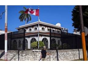 A man walks beside Canada's embassy in Havana, Cuba, on April 17, 2018. Canada is reviewing its diplomatic presence in Cuba following another confirmed illness among embassy staff. A total of 13 diplomats posted to the Canadian embassy in Havana, as well as their dependants, have come down with a mysterious illness that causes dizziness, headaches and trouble concentrating.