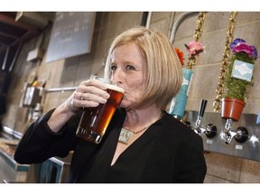 Alberta Premier Rachel Notley drinks a beer while touring the Cold Garden Beverage Company in Calgary on March 27, 2017. The Alberta government is retreating on craft beer subsidies after they were ruled unconstitutional but will open a new front by targeting the province of Ontario for what it says are its unfair trade barriers. Finance Minister Joe Ceci says the province will cancel payments made to assist smaller Alberta craft brewers by Dec. 15 to bring its beer regulations in compliance with Canadian trade law.