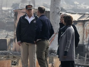 President Donald Trump talks with FEMA Administrator Brock Long, Jody Jones, Mayor of Paradise, and California Gov. Jerry Brown, second from right during a visit to a neighborhood impacted by the wildfires, Saturday, Nov. 17, 2018, in Paradise, Calif. (AP Photo/Evan Vucci)